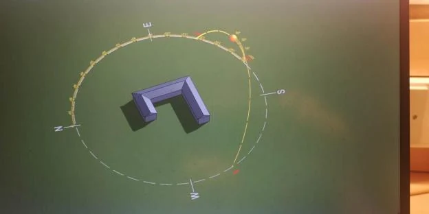Design-stage solar study showing the courtyard building and a sun-path diagram on a screen